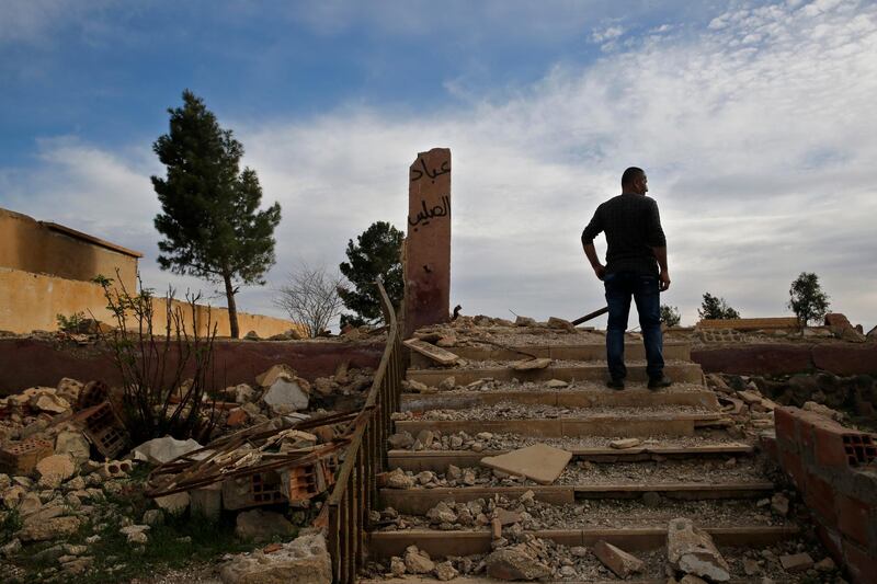 Zaya Youkhana, an Assyrian Christian stands on the rubble of a destroyed church that blown up by Islamic State militants in 2015 with Arabic that reads, "Worshippers of the cross," in the deserted village of Tal Jazeera, northern Syria. The Qatar-based Syrian Network for Human Rights, a Syrian war monitor associated with the opposition said in its report that over 120 Christian places of worship have been damaged or destroyed by all sides in the country’s eight-year conflict.  AP