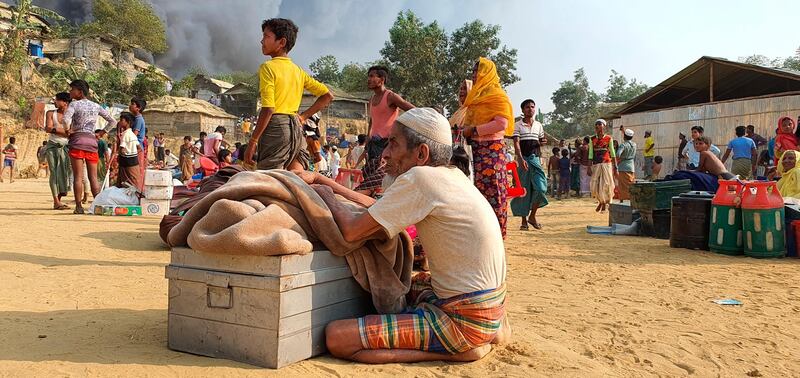 Rohingya refugees salvage their belongings and watch the smoke rising following a fire at the Rohingya refugee camp in Balukhali, southern Bangladesh. AP Photo