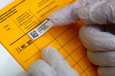 Medical staff fill in a vaccination pass at the local vaccination centre in Ebersberg near Munich, Germany, Monday, March 22, 2021. (AP Photo/Matthias Schrader)