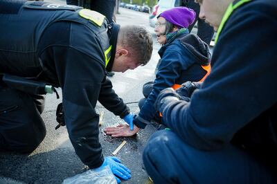 This activist's hand was firmly glued to the street near a Berlin landmark on Friday. AP 