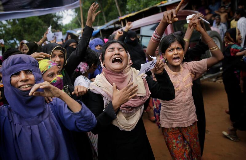 FILE - In this Saturday, Aug. 25, 2018, file photo, Rohingya women cry as they shout slogans during a protest rally to commemorate the first anniversary of Myanmar army's crackdown which lead to a mass exodus of Rohingya Muslims to Bangladesh, at Kutupalong refugee camp in Bangladesh. China is denying it blocked action by the United Nations on the issue of Muslim Rohingya refugees but says it doesn't believe sanctions or criticism of Myanmar's government will help resolve the crisis. (AP Photo/Altaf Qadri, File)