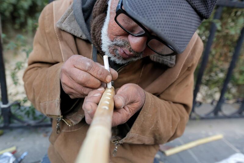 Saad Attab, 58, an Iraqi from Samarra city, makes a flute on a street in Damascus, Syria. Attab sought safe haven in Damascus in 2003 with the US invasion of Iraq. EPA