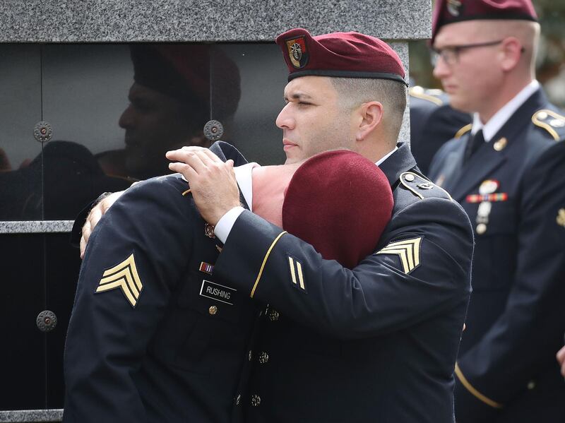 (FILES) In this file photo taken on October 21, 2017 members of the 3rd Special Forces Group (Airborne) 2nd battalion Fse comfort each other as they attend the burial service for U.S. Army Sgt. La David Johnson at the Memorial Gardens East cemetery in Hollywood, Florida. Sgt. Johnson and three other American soldiers were killed in an ambush in Niger on Oct. 4.   The United States on Friday offered a $5 million reward for information about the leader of an Islamic State branch which claimed responsibility for an ambush in Niger two years ago that left four US servicemen dead. / AFP / GETTY IMAGES NORTH AMERICA / JOE RAEDLE

