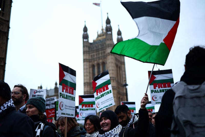 Demonstrators wave Palestinian flags in Parliament Square, London. AFP