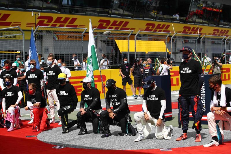 Lewis Hamilton, centre, and fellow F1 drivers take a knee and wear anti-racism T-shirts before the Styrian Grand Prix on Sunday, July 12, while a few drivers remain standing. AFP