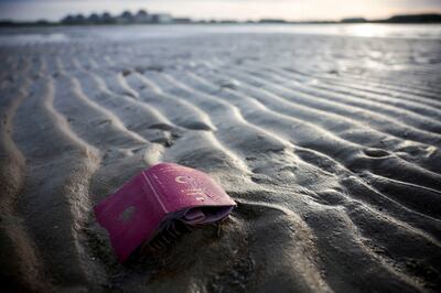 A passport is seen on the beach after a group of migrants travelled on an inflatable dinghy to leave the coast of northern France and to cross the English Channel. Reuters