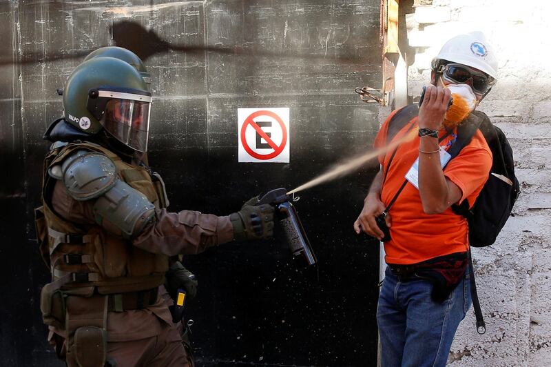 A member of the Chilean security forces uses pepper spray on a human rights' observer during a protest against Chile's government in Valparaiso. Reuters