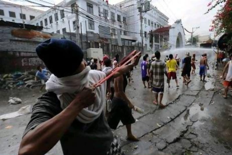 Squatters use rocks, bottles and sling shots against workers trying to enforce a demolition order on informal settlers’ homes to give way for the construction of a city hall building in Manila in January this year.