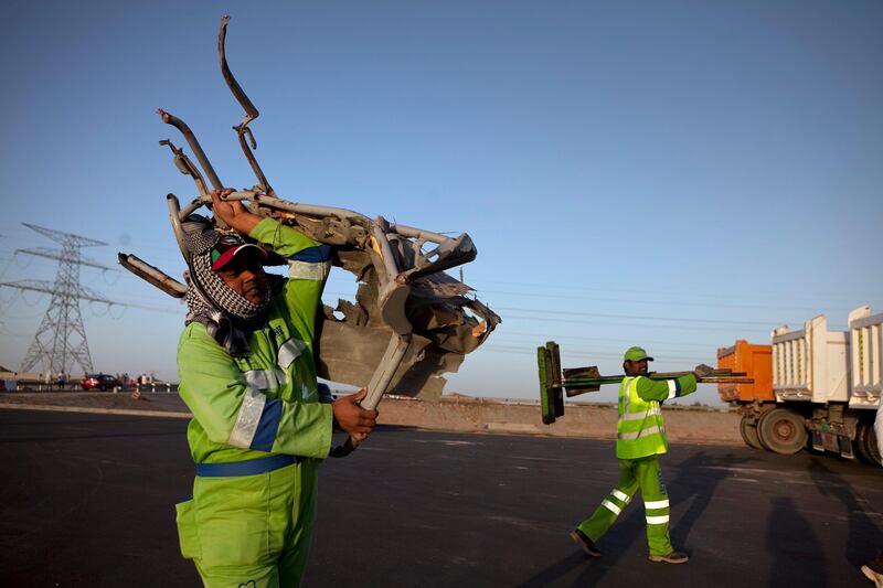 Al Ain, United Arab Emirates, February 4, 2013: 
Workers clean up the remnants of a tragic traffic accident, which involved a truck and a bus full of laborers and has left 22 people dead and sent many to a hospital, on Monday early evening, Feb. 4, 2013, at the scene of the accident, about 35km from Al Ain on the Abu Dhabi - Al Ain road. The accident happened at 7:30am as the bus, loaded with 45 workers, 95 percent of which were reported Bangladeshi, carried the people to their work at a nearby palace. The bus travelers were employees of the Al Hakeem Decorations and have worked at the palace as maintenance crew.
Silvia Razgova / The National

