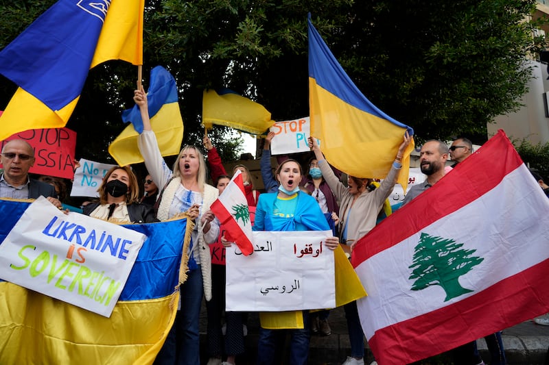 Ukrainians in Lebanon hold placards and chant slogans during a protest against Moscow's attack on their country, outside the Russian embassy in Beirut, Lebanon. AP Photo