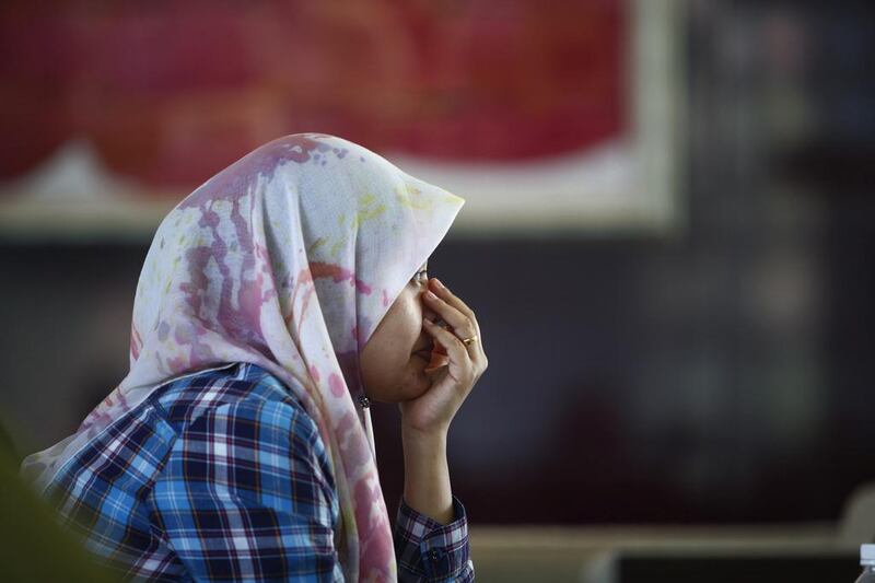 Arni Marlina, 36, a family member of a passenger on-board the missing Malaysia Airlines flight MH370, cries at a hotel in Putrajaya. Malaysian authorities are investigating the identities of four passengers on the flight. Samsul Said / Reuters