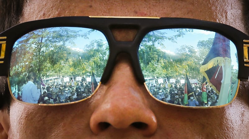 Protesters reflected in the sunglasses of a demonstrator during a rally in support of Afghanistan's people after the takeover of the country by the Taliban, at the Place de la Republique, in Paris on September 5, 2021. AFP