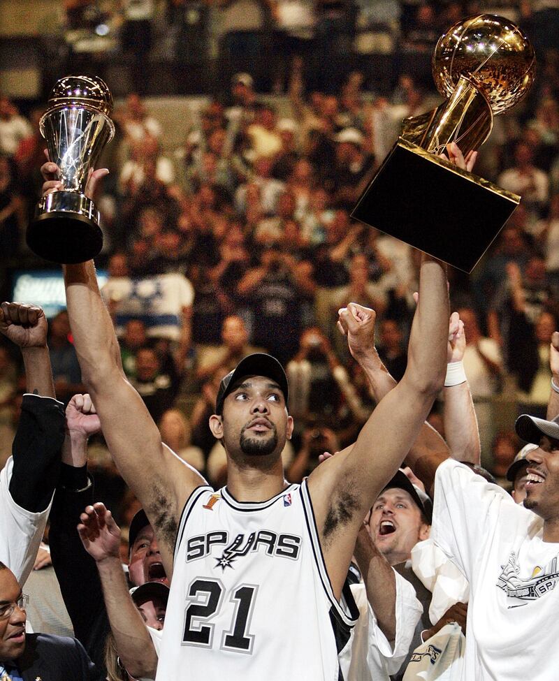 San Antonio Spurs' Tim Duncan holds his MVP trophy, left, and the NBA championship trophy in 2005. AP