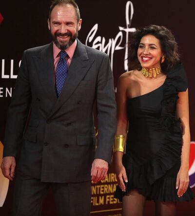 English actor Ralph Fiennes and Egyptian actress and architect Shahira Fahmy walk on the red carpet during the 40th edition of the Cairo International Film Festival on November 26, 2018. / AFP / CAIRO INTERNATIONAL FILM FESTIVA / PATRICK BAZ
