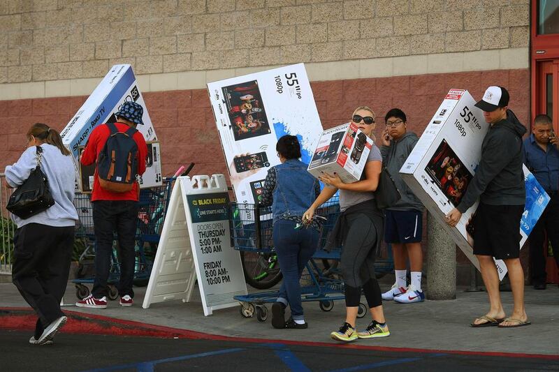 Shoppers with their arms full walk to their cars during the Black Friday sales at a Best Buy store in Culver City, California. AFP