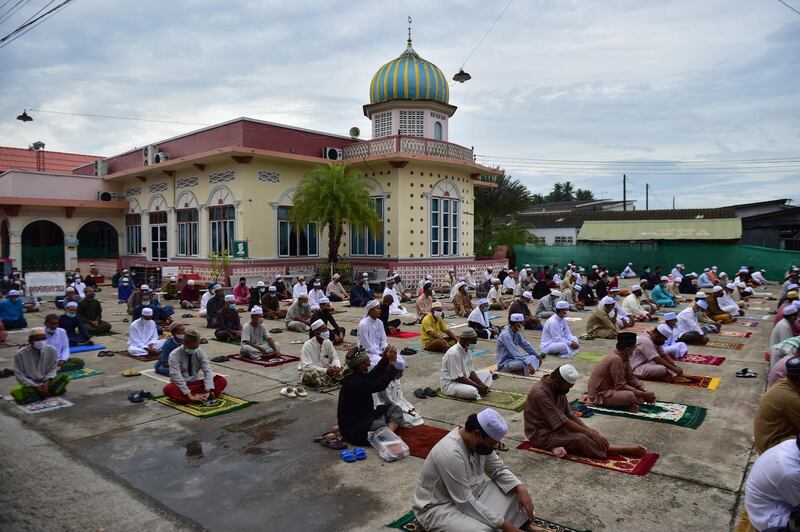 Muslims pray outside a mosque due to limitations and restrictions to halt the spread of the COVID-19 coronavirus during the Eid al-Adha festival in Thailand's southern province of Narathiwat on July 31, 2020. Muslims are celebrating Eid al-Adha (the feast of sacrifice), the second of two Islamic holidays celebrated worldwide marking the end of the annual pilgrimage or Hajj to the Saudi holy city of Mecca. / AFP / Madaree TOHLALA
