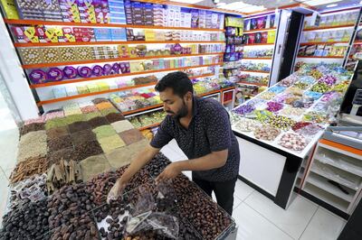 Dubai, United Arab Emirates - May 20, 2019: Arif Arif gathers dates for a customer at Mahyaee Trading. Monday the 20th of May 2019. Bur Dubai, Dubai. Chris Whiteoak / The National