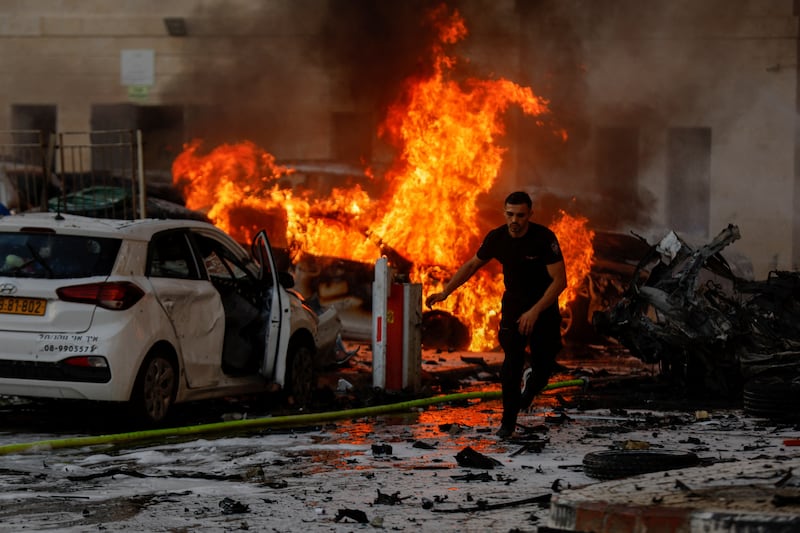 A man seeks cover after rockets launched from the Gaza Strip land in Ashkelon, Israel. Reuters