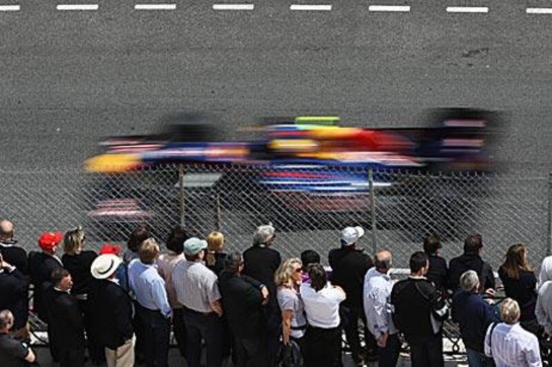 The crowds watch Mark Webber tear round the track on his way to pole position in Monte Carlo yesterday.