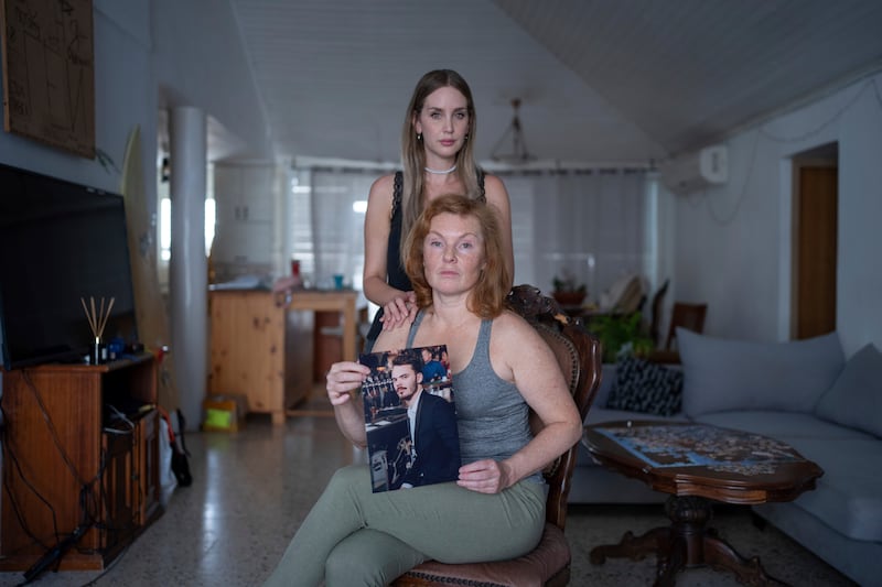 Evgenia Kozlov with a portrait of her son, Andrey, 27, and his girlfriend, Jenifer Master. Mr Kozlov, a Russian citizen, was abducted by Hamas militants. AP