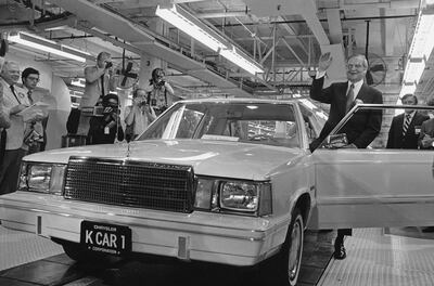 FILE - In this Aug. 6, 1980, file photo, Chrysler Chairman Lee Iacocca, right, waves as he steps into the first K-Car at ceremonies in Detroit, Mich. The new front-wheel-drive compact was the driven out of the plant past cheering auto workers by Iacocca. Former Chrysler CEO Iacocca, who became a folk hero for rescuing the company in the '80s, has died, former colleagues said Tuesday, July 2, 2019. He was 94. (AP Photo/Dale Atkins, File)