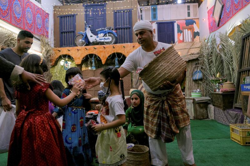 A man distributes gifts to children as they celebrate Gargee'an in Qatif, Saudi Arabia. Reuters