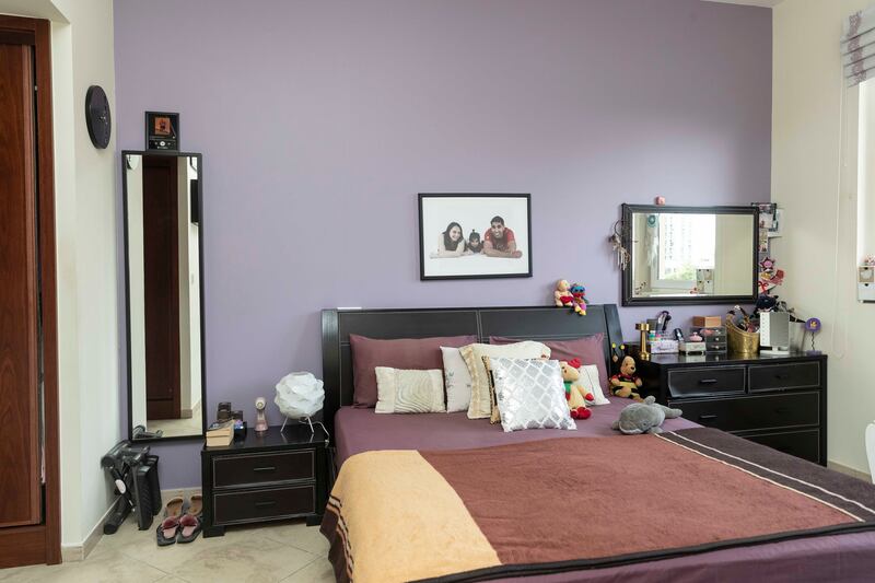 The purple master bedroom of the second-floor apartment