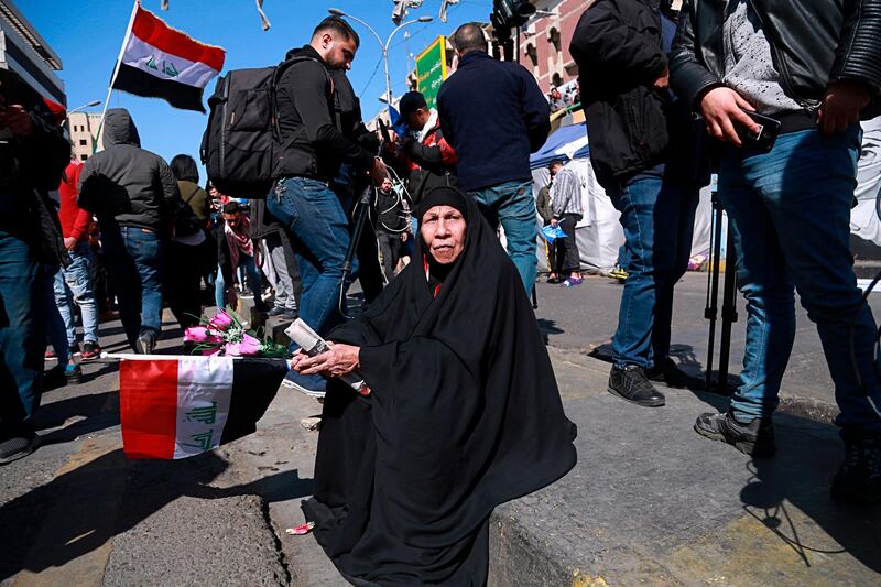 A woman holds a national flag during a protest in Tahrir Square. AP Photo