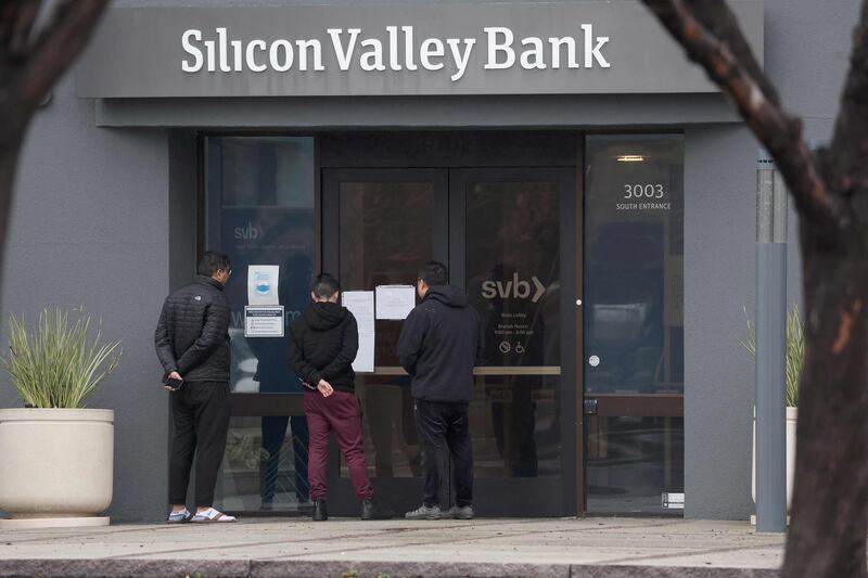 Employees stand outside the headquarters of Silicon Valley Bank in Santa Clara, California, after it was closed. AFP