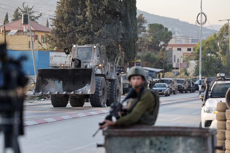 An Israeli security forces bulldozer arrives at a military roadblock after reports of Saturday's attack in Huwara in the occupied West Bank. AFP