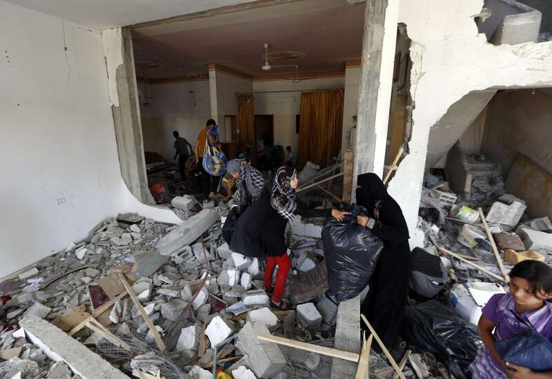 A Palestinian family return to their destroyed home in the northern Gaza Strip city of Beit Hanun. Mohammed Abed / AFP