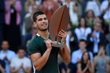 Spain's Carlos Alcaraz celebrates with the trophy after winning the 2022 ATP Tour Madrid Open tennis tournament men's singles final match against Germany's Alexander Zverev at the Caja Magica in Madrid on May 8, 2022.  (Photo by OSCAR DEL POZO  /  AFP)