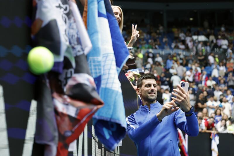Novak Djokovic takes a selfie with a spectator after winning his match against Adrian Mannarino. EPA