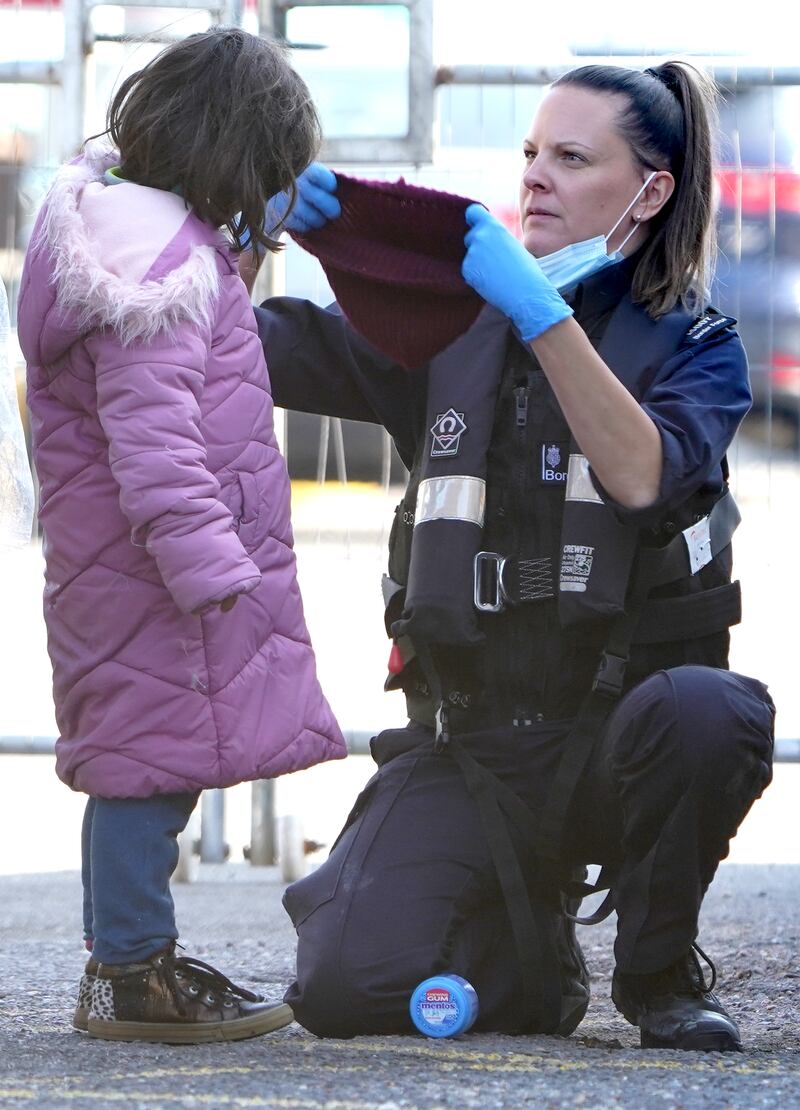 A girl is helped by a Border Force officer.