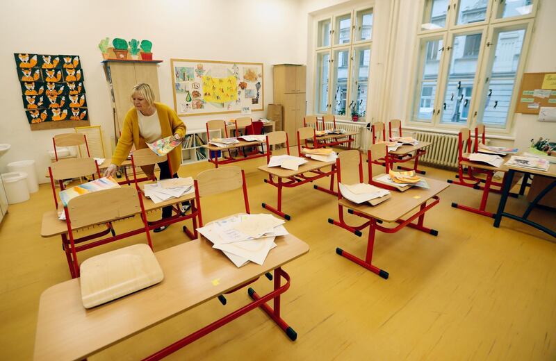 A teacher sorts drawings in an empty classroom at a closed school in Prague, Czech Republic. Amid widespread efforts to curb the new wave of coronavirus infections in one of the hardest hit European countries, the Czech Republic closed all of its schools. AP Photo