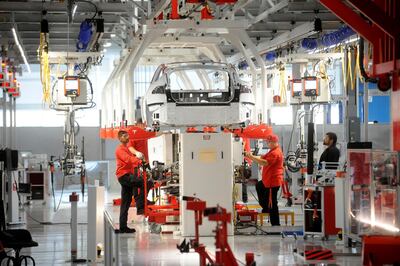 FILE PHOTO: Tesla workers examine a Model S used for training and tool calibration at the company's factory in Fremont, California, June 22, 2012. REUTERS/Noah Berger/File Photo