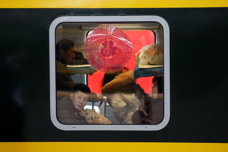 Travellers sit in a train at Beijing Railway Station in China. Reuters