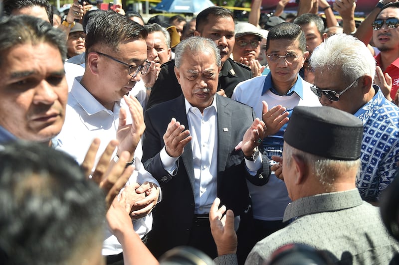 Former Malaysian prime minister Muhyiddin Yassin, centre, arrives at the anti-corruption agency's headquarters on Thursday. AFP
