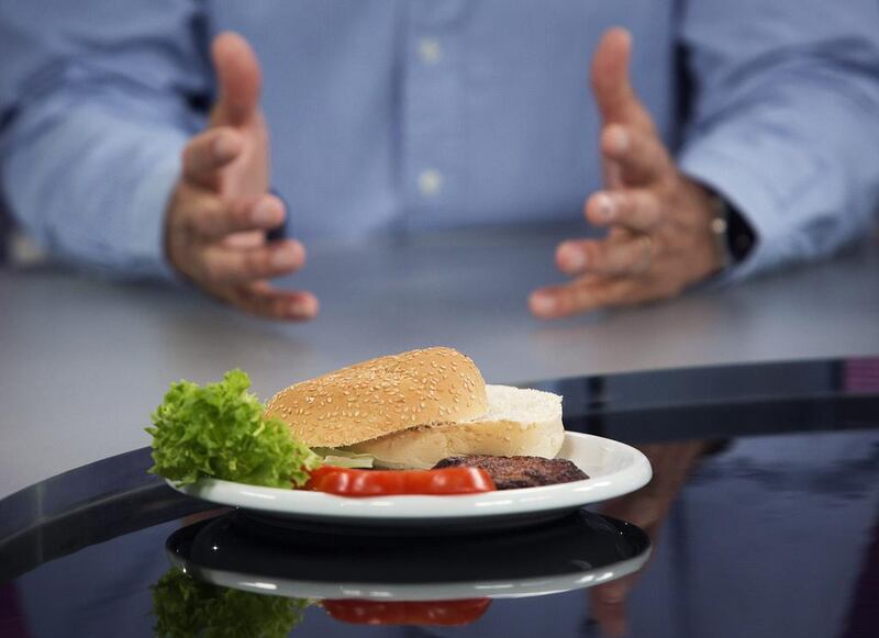 The world's first beef burger created from stem cells harvested from a living cow sits in front of Mosa Meat's Mark Post. Bloomberg