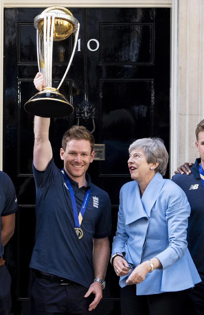 British prime minister Theresa May looks up as England captain Eoin Morgan holds aloft the World Cup trophy outside 10 Downing Street. AFP