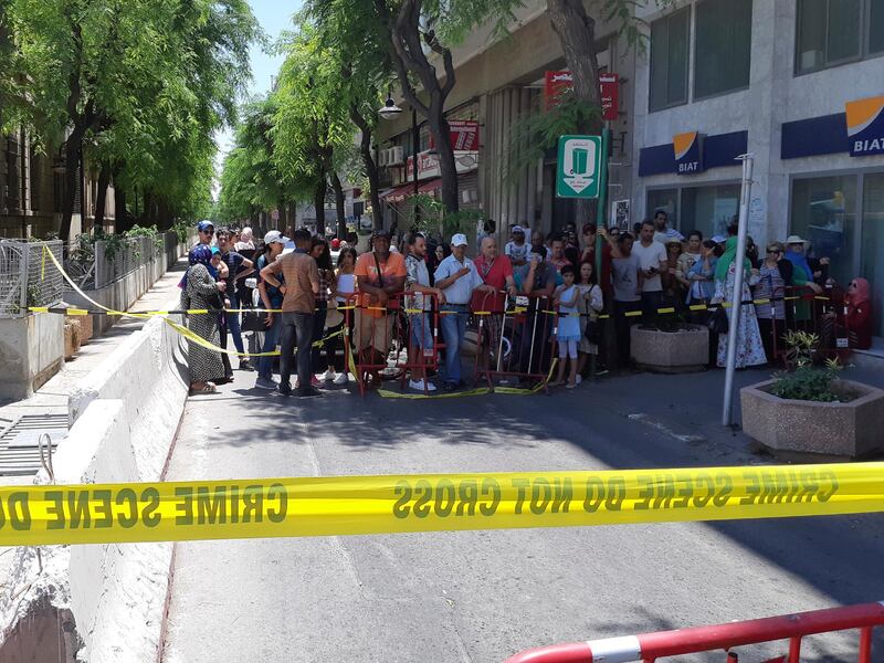 People are prevented to enter a security area after an explosion in Tunis, Thursday June 27, 2019. The Tunisian Interior ministry said one police officer has died in the suicide bombing targeting a police patrol in a busy commercial street in central Tunis. (AP Photo/Riadh Dridi)