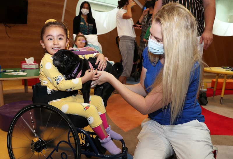 Patients meet with Millie the Pug during the arts and crafts session at Al Jalila Children's Speciality Hospital in Dubai on 10 October, 2021. Pawan Singh / The National