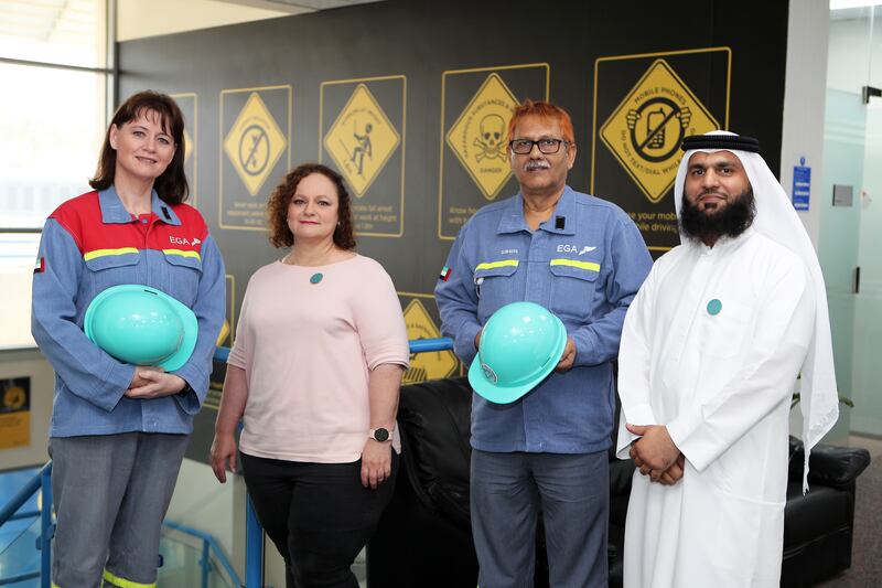 From left, Elizabeth Bredell, Tersia Corbitt, Mohammad Zahiruddin and Omer Jeelani at Emirates Global Aluminium in Dubai. Trained mental health first aiders wear aqua helmets. Pawan Singh / The National