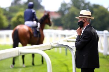 A course steward adjusts his mask during Day One of Royal Ascot in the UK, as racing resumes behind closed doors after the outbreak of the coronavirus disease.  Reuters