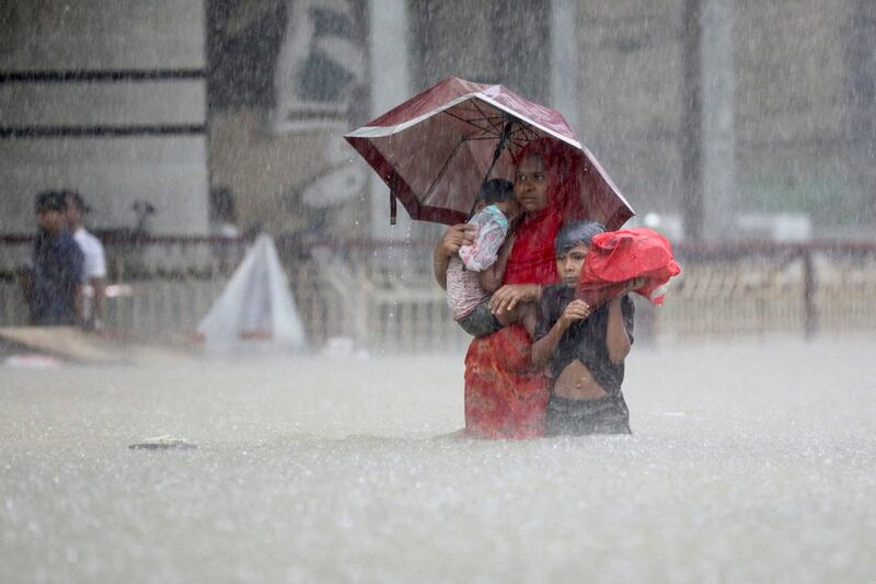 People wade through water as they look for shelter, amid flooding in Sylhet, Bangladesh. Reuters