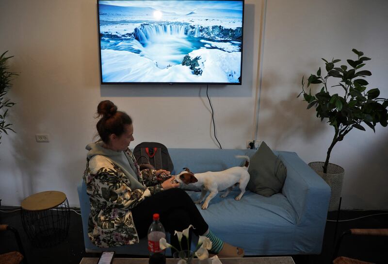 A Ukrainian refugee who fled the Russian invasion of her country sits with her pet at a holiday village turned into temporary refuge in Goren, northern Israel. AFP