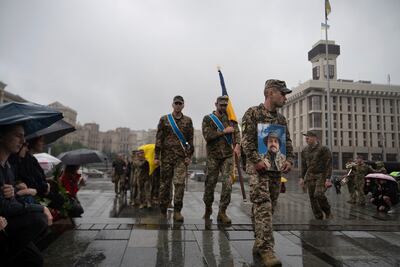 Ukrainian troops carry the coffin of a fallen serviceman in Kyiv's Independence Square. AP 