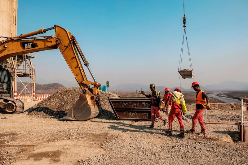 Workers walk next to a power shovel at the Grand Ethiopian Renaissance Dam (GERD), near Guba in Ethiopia.  AFP