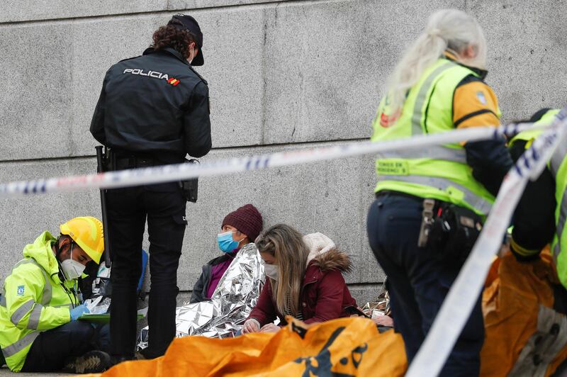 A police officer and medical personnel assist people after the explosion in Madrid. Reuters