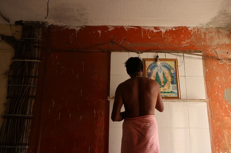 A resident at prayer in a corridor at the Worli building